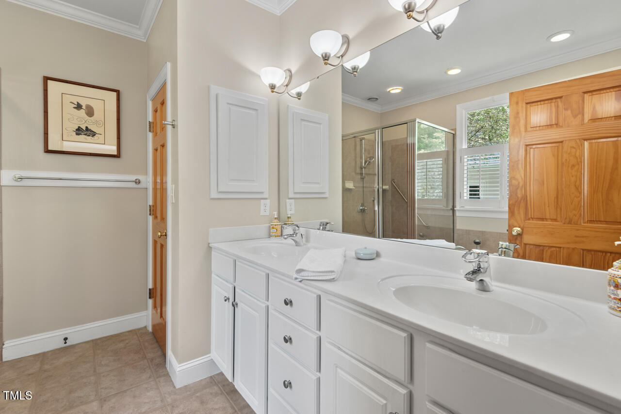 30119 Settle Chapel Hill, NC 27517 - Photo 36 of 49 a bathroom with double vanity sinks a vanity a lamp and a shower