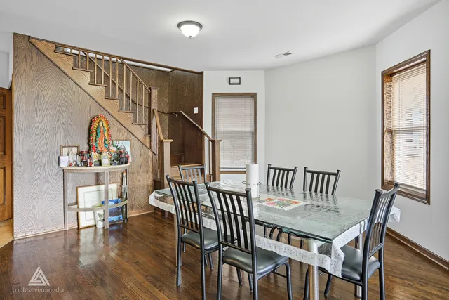 a view of a dining room with furniture a rug and wooden floor