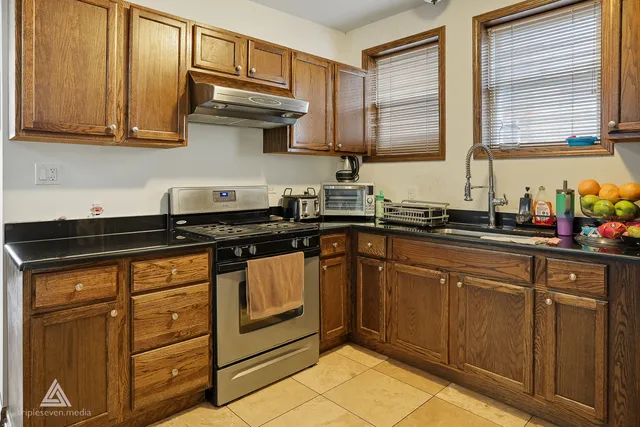 a kitchen with stainless steel appliances granite countertop a sink stove and cabinets