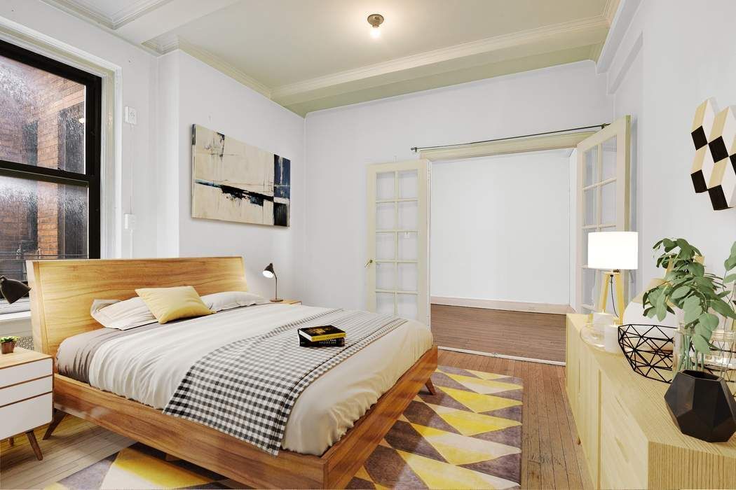 64 East 86th Street, Unit 11A Manhattan, NY 10028 - Photo 4 of 11 a bedroom with a bed and dresser with mirror