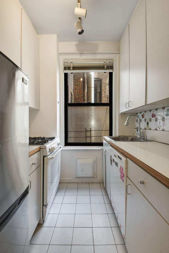 64 East 86th Street, Unit 11A Manhattan, NY 10028 - Photo 6 of 11 a kitchen with stainless steel appliances granite countertop a refrigerator and a sink