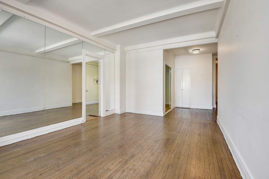 64 East 86th Street, Unit 11A Manhattan, NY 10028 - Photo 8 of 11 an empty room with wooden floor and closet