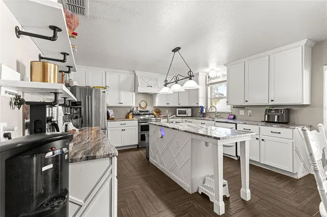 a kitchen with white cabinets stainless steel appliances and sink
