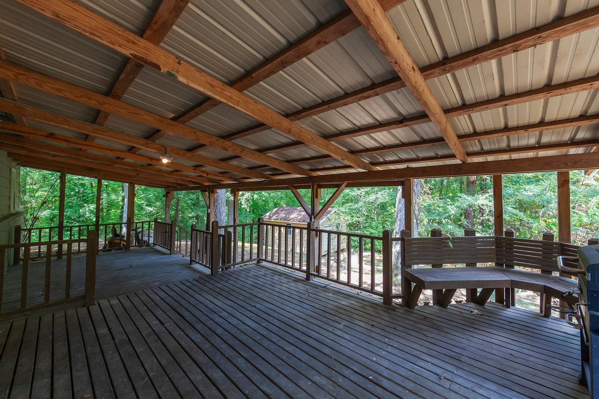 795 Burnett Mills Road Bolivar, TN 38008 - Photo 25 of 29 a view of a patio with table and chairs a barbeque with wooden floor and roof with a barbeque grill