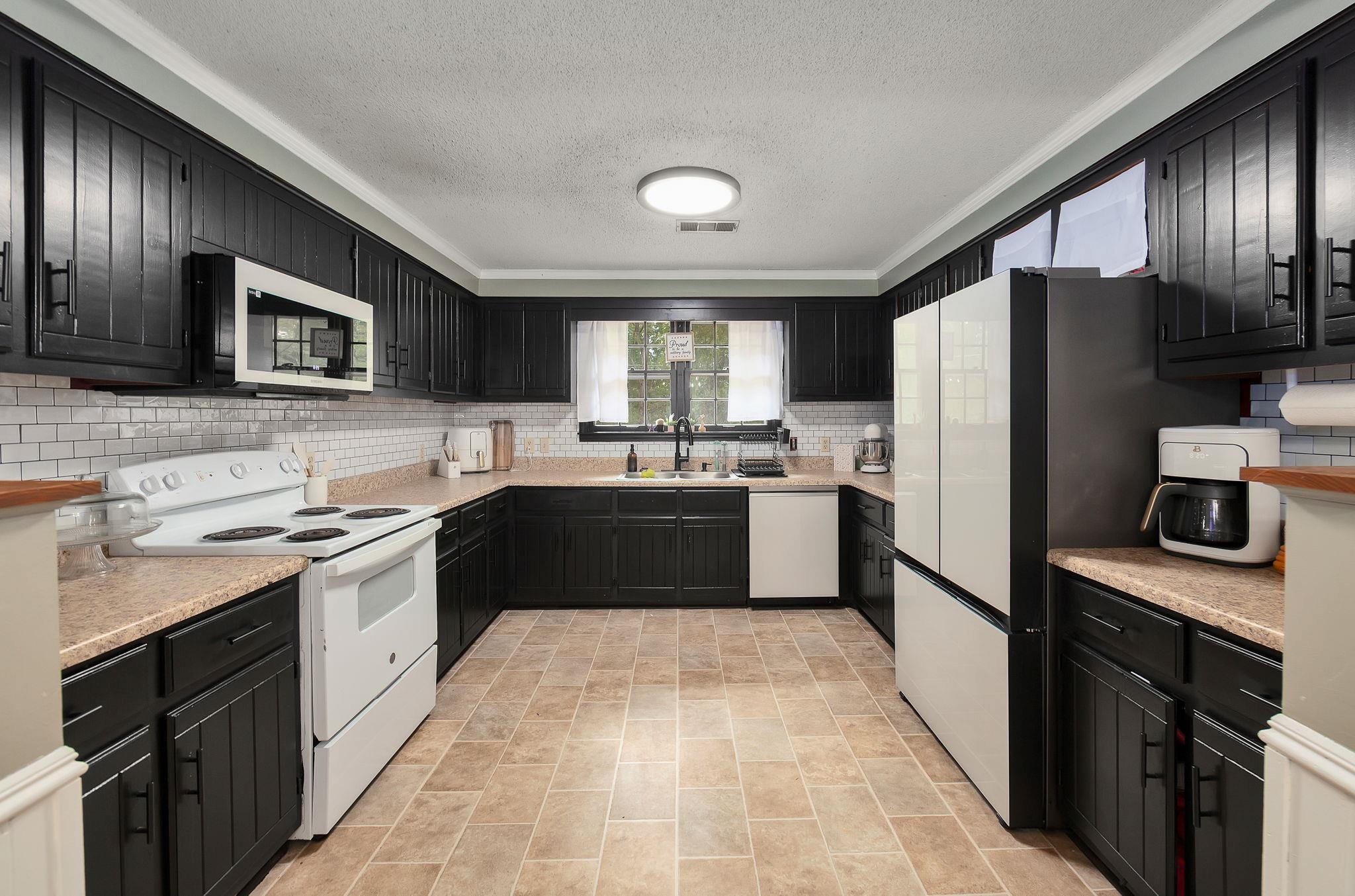 795 Burnett Mills Road Bolivar, TN 38008 - Photo 4 of 29 a kitchen with a refrigerator sink and wooden cabinets