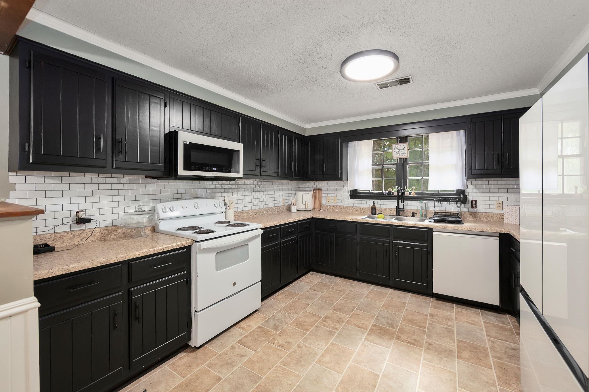 795 Burnett Mills Road Bolivar, TN 38008 - Photo 5 of 29 a kitchen with a sink stove and microwave