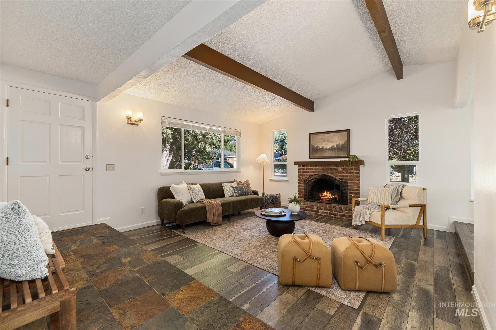 2302 Pendleton Street Boise, ID 83705 - Photo 7 of 35 Living room featuring vaulted ceilings with exposed beams, a brick fireplace, large picture windows, and mixed-material flooring