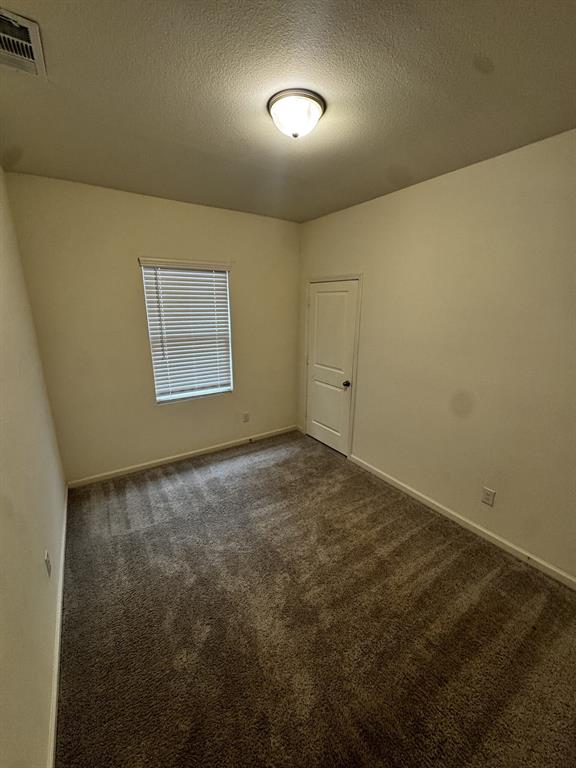 1813 Chapel Hill Road Princeton, TX 75407 - Photo 15 of 20 Neutral tone wall paint with a textured ceiling finish, recessed window with blinds, and flush-mount ceiling light