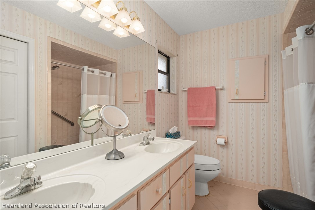 5802 Golden Road Sebring, FL 33875 - Photo 17 of 37 a bathroom with a sink vanity mirror and toilet