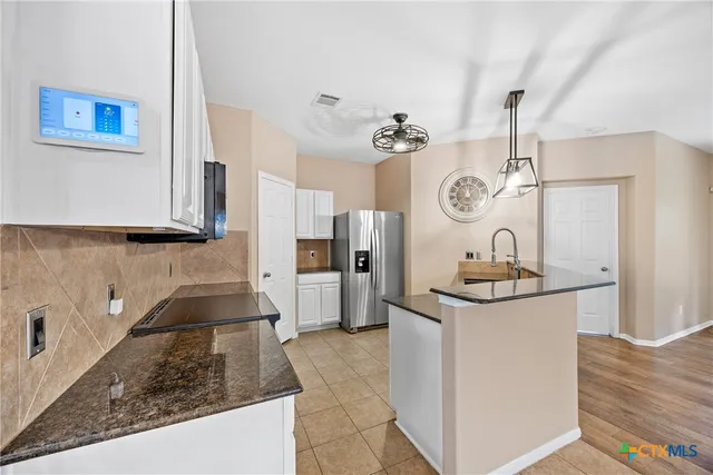 a kitchen with stainless steel appliances granite countertop a sink and a refrigerator