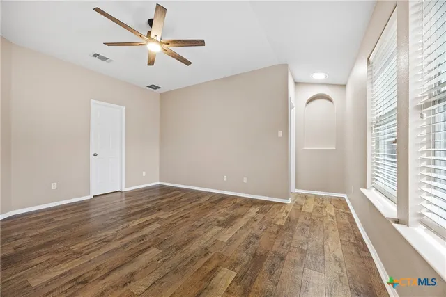 wooden floor in an empty room with a window