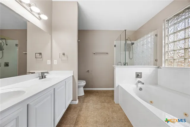 a bathroom with a tub a sink and a large mirror