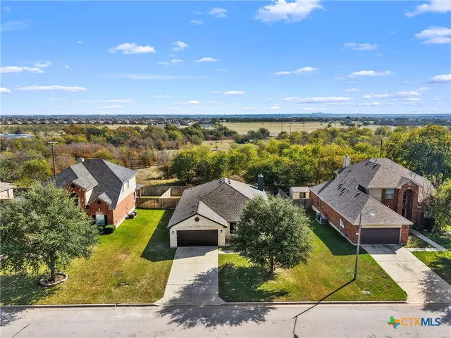 an aerial view of residential houses with outdoor space and ocean