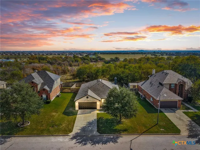 an aerial view of residential houses with outdoor space and ocean view