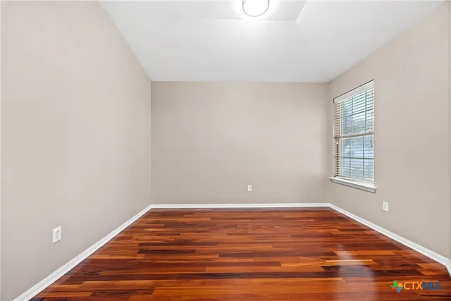 a view of room with window and wooden floor