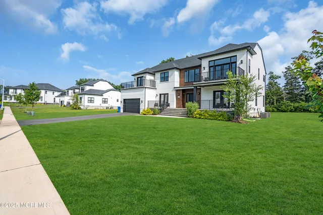 a front view of a house with a garden and trees