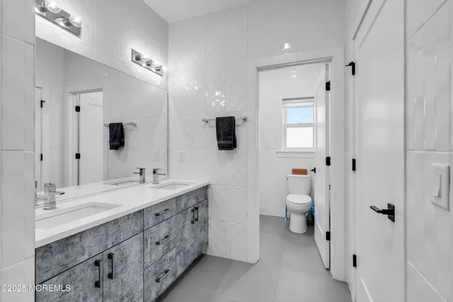 a spacious bathroom with a double vanity sink mirror and toilet