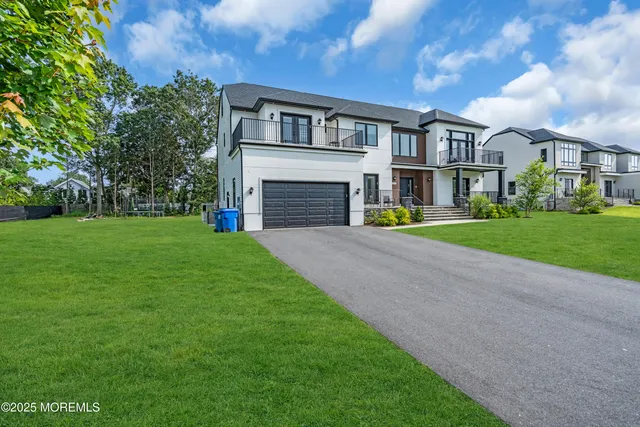 a view of house with a big yard and large trees