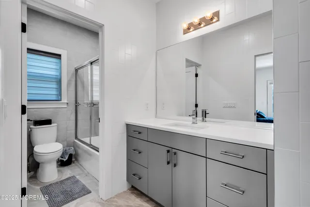 a bathroom with a sink a toilet a shower and a mirror