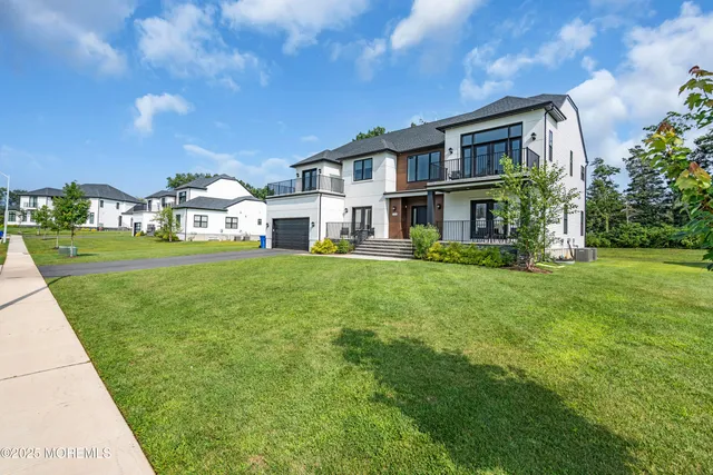 a view of a house with a big yard and large trees