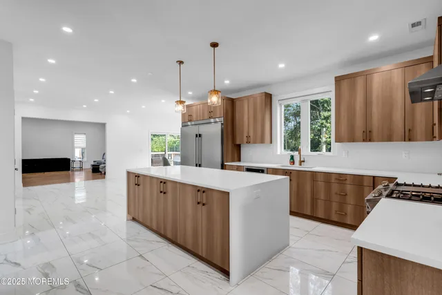 a kitchen with kitchen island granite countertop a sink counter top space appliances and a window