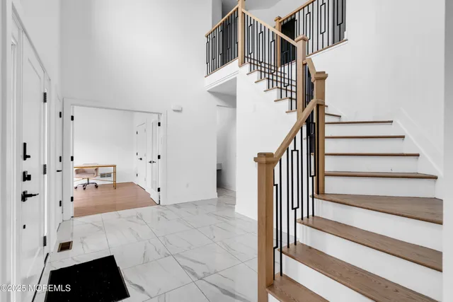 a view of staircase with white walls and lots of frames on wall