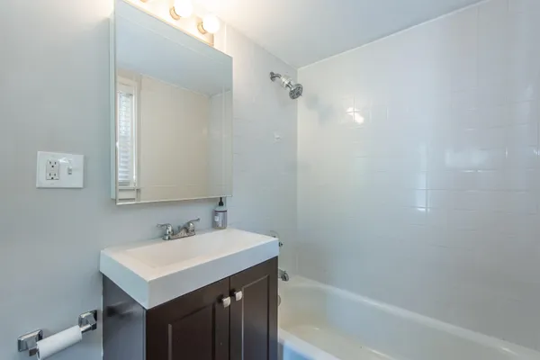 a bathroom with a sink mirror and a bathtub