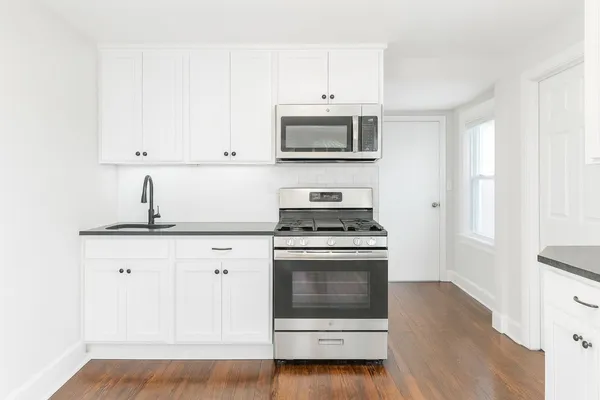 a kitchen with stainless steel appliances white cabinets and a sink