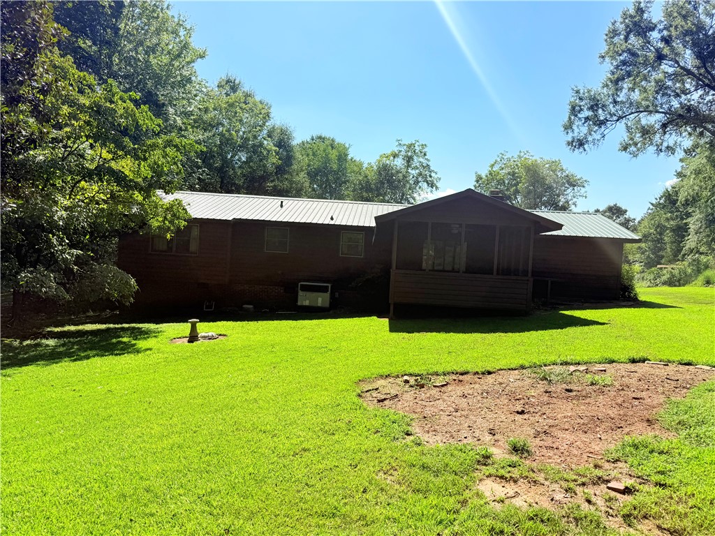 407 Seawright Drive Pendleton, SC 29670 - Photo 2 of 29 Mature trees frame a rustic home featuring a metal roof and a spacious screened porch.