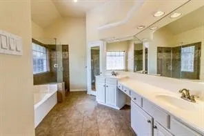 a spacious bathroom with a granite countertop tub sink and a mirror
