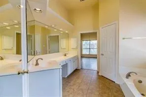 a bathroom with a tub sink and mirror