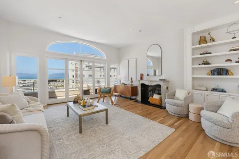 a living room with furniture fireplace and a large window