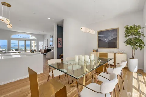 a dining room with furniture and a floor to ceiling window