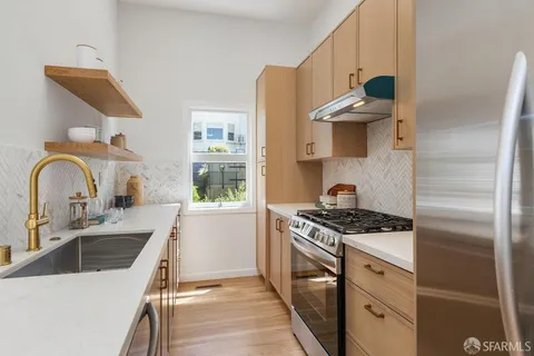 a kitchen with stainless steel appliances granite countertop a sink stove and refrigerator