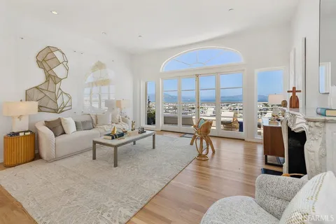 a living room with fireplace furniture and a large window