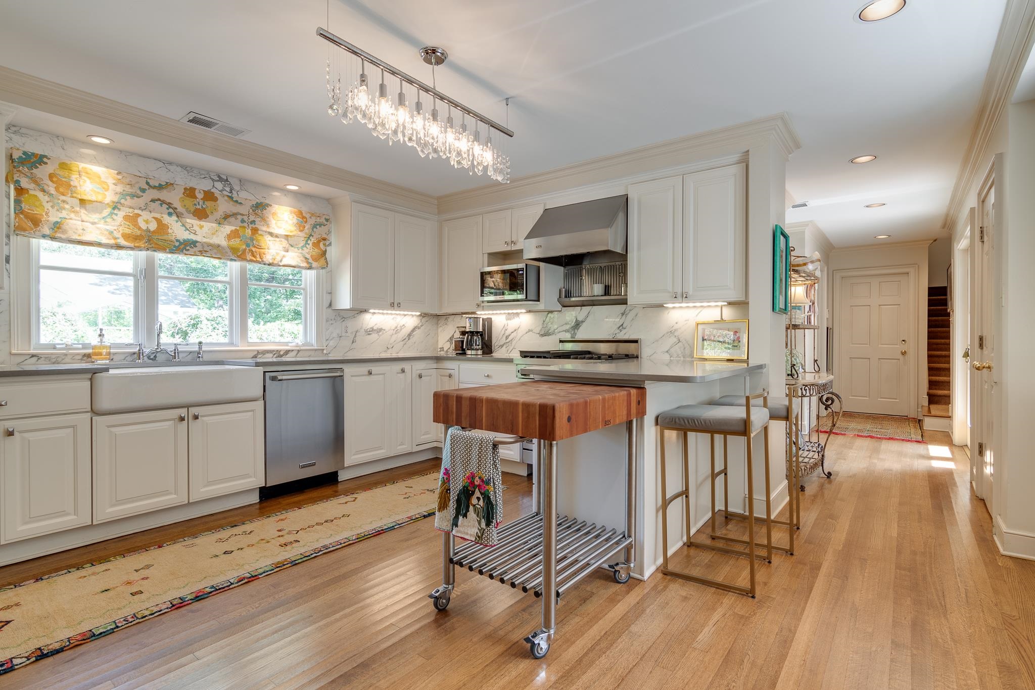 338 Greenway Road Memphis, TN 38117 - Photo 27 of 40 a kitchen with stainless steel appliances a microwave a stove a sink dishwasher a microwave oven and a dining table with wooden floor