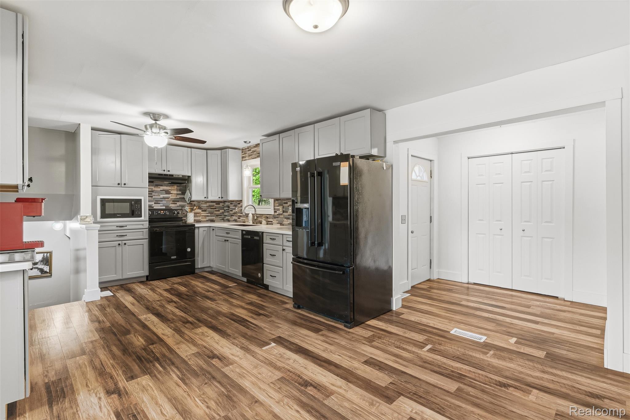 14433 Tuscola Road Clio, MI 48420 - Photo 11 of 43 Kitchen with black appliances, light countertops, backsplash, gray cabinetry, and dark wood-style floors