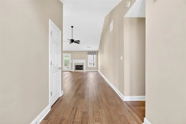 a view of a hallway with wooden floor and a kitchen