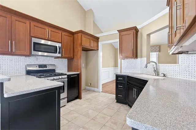 a kitchen with stainless steel appliances granite countertop a stove sink and cabinets