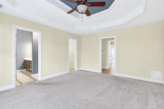 a view of an empty room and chandelier fan