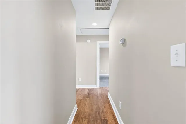 a view of a hallway with wooden floor