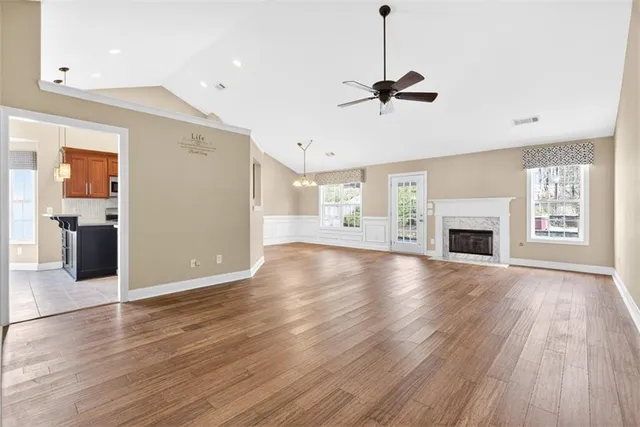 a view of empty room with wooden floor and fireplace