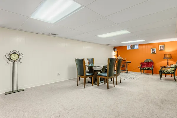 a dining room with furniture and a floor to ceiling window