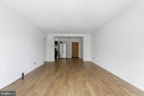 a view of empty room with wooden floor