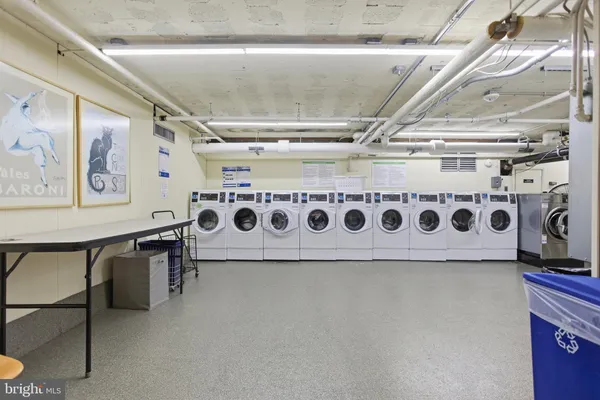 a utility room with stainless steel appliances lots of white walls