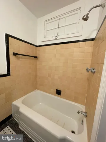 a bathroom with a white bath tub and a shower