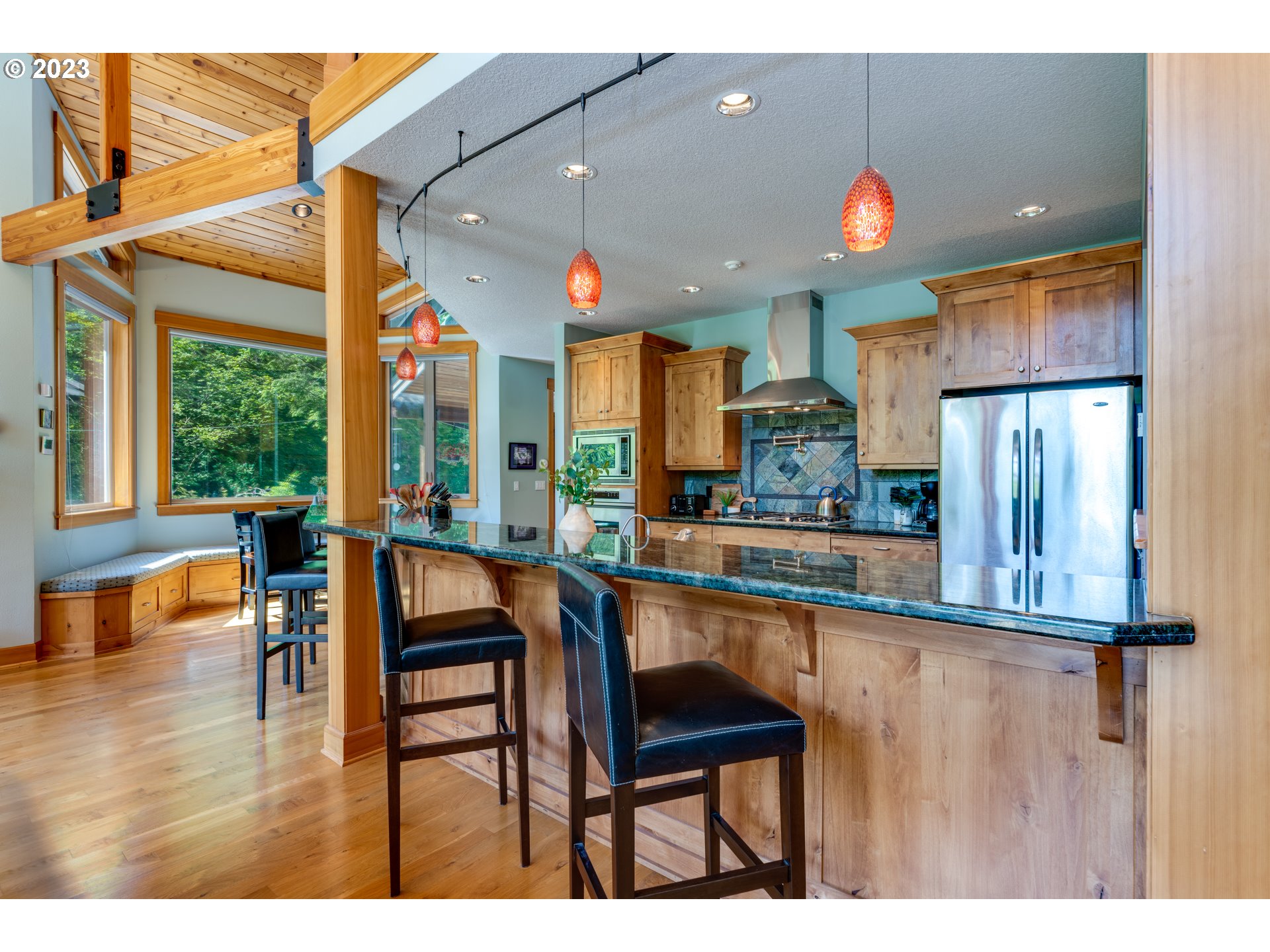 20715 East Glacier View Road Rhododendron, OR 97049 - Photo 13 of 41 a kitchen with stainless steel appliances granite countertop table chairs and a view of living room
