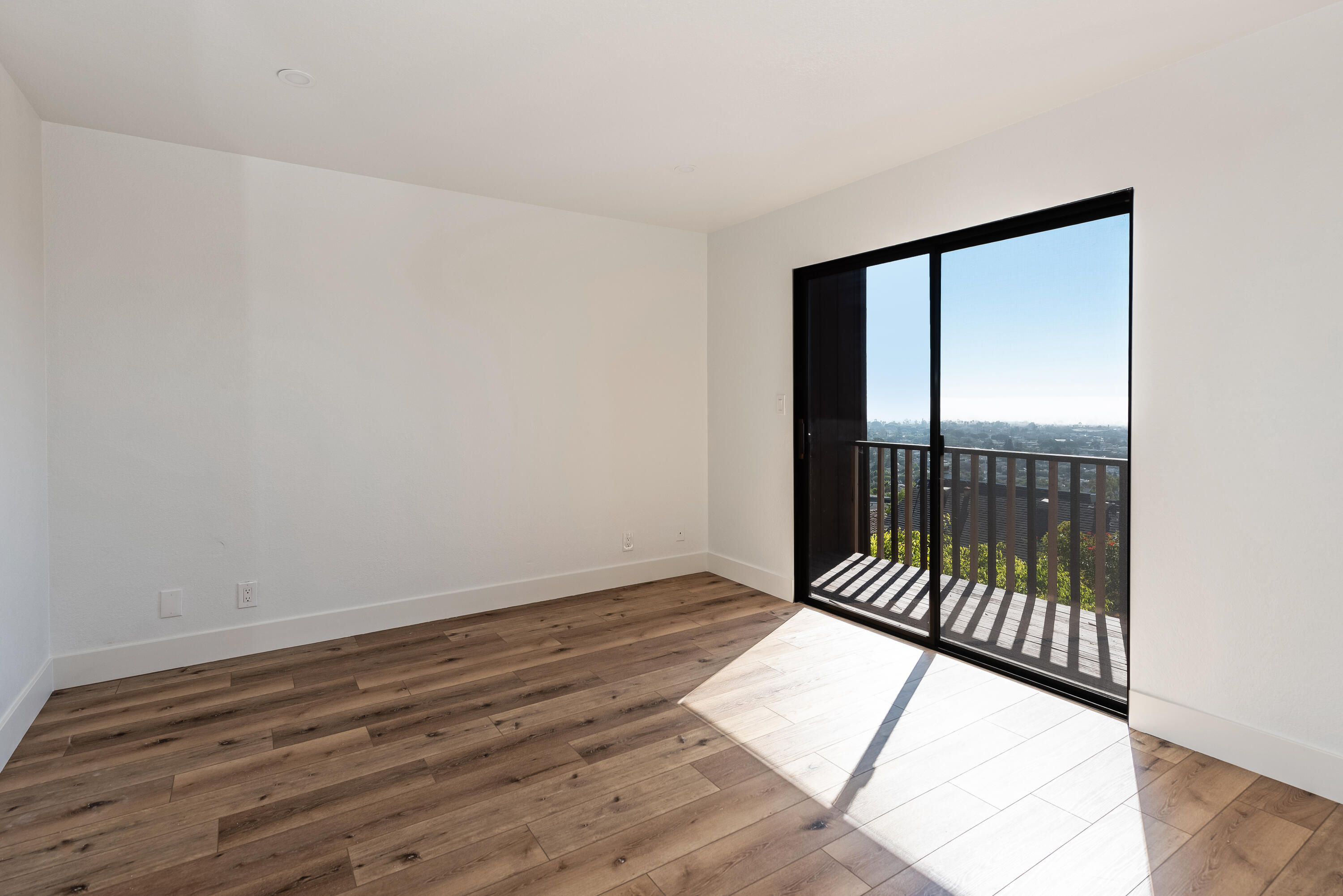 34 Rubio Road Santa Barbara, CA 93103 - Photo 14 of 22 an empty room with wooden floor and windows
