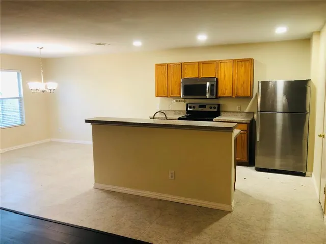 a kitchen with stainless steel appliances a refrigerator and a stove