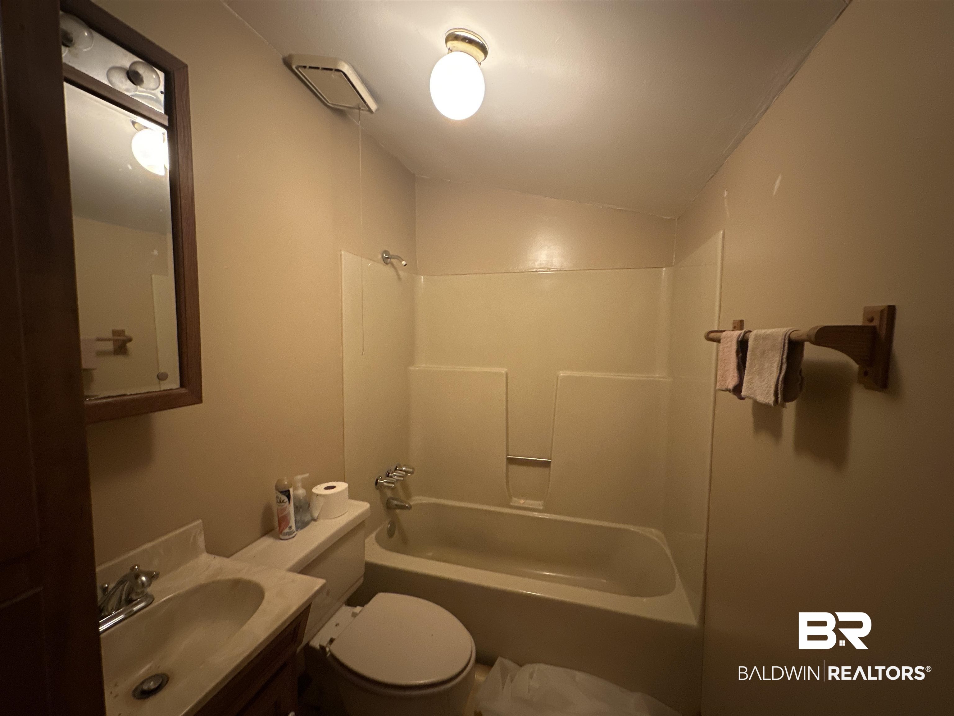 9520 C Four Mile Road Irvington, AL 36544 - Photo 23 of 32 Full bathroom featuring bathtub / shower combination, vanity, toilet, and vaulted ceiling